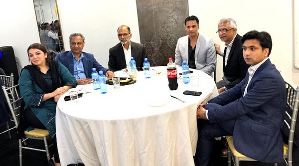 A group of men sitting around a round table
Description automatically generated