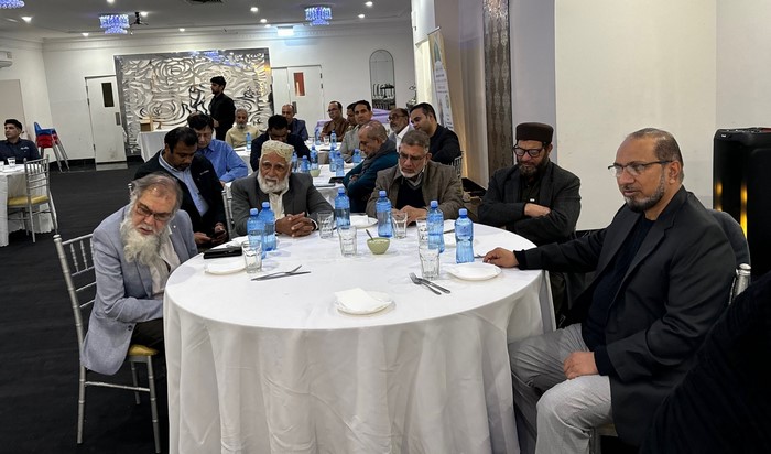 A group of men sitting at a round table
Description automatically generated