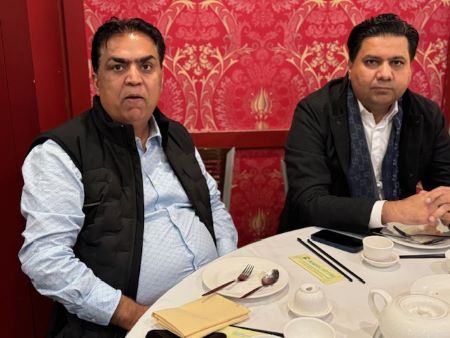 Two men sitting at a table
Description automatically generated