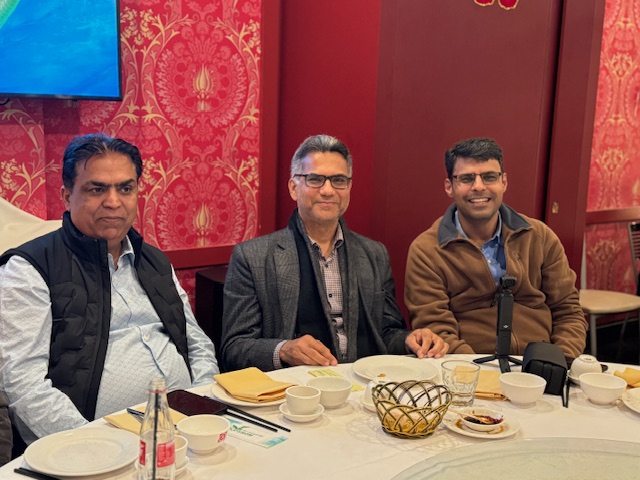A group of men sitting at a table
Description automatically generated