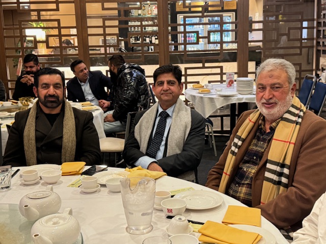 A group of men sitting at a table
Description automatically generated