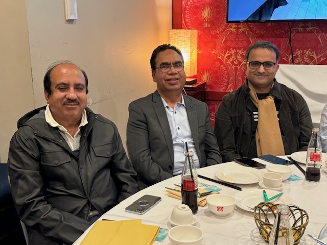 A group of men sitting at a table
Description automatically generated