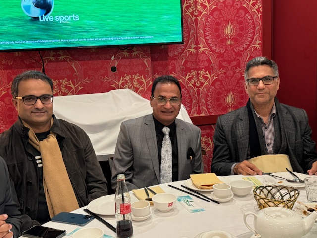 A group of men sitting at a table
Description automatically generated