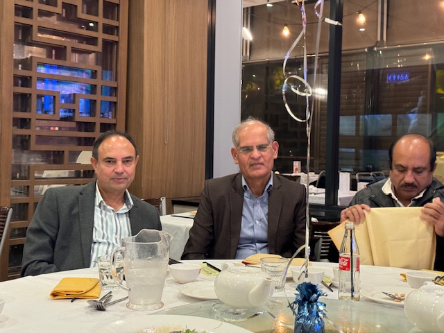 A group of men sitting at a table
Description automatically generated