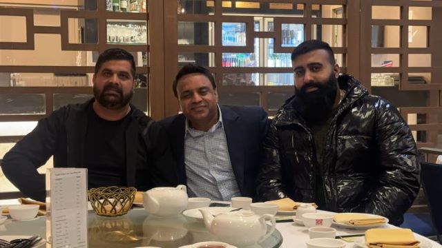 A group of men sitting at a table
Description automatically generated