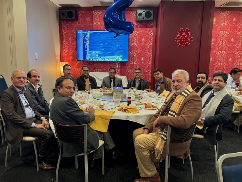 A group of men sitting around a table
Description automatically generated