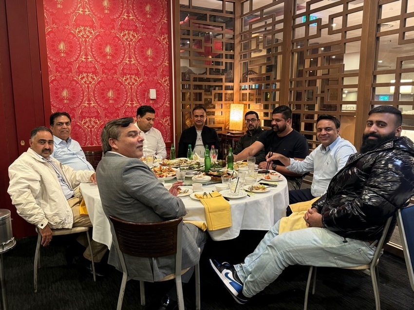A group of people sitting around a table
Description automatically generated
