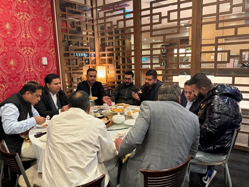 A group of people around a table
Description automatically generated