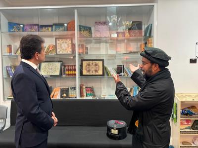 Two men standing in front of a glass display
Description automatically generated