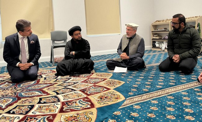 A group of men sitting on the floor
Description automatically generated