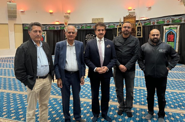 A group of men standing in a room
Description automatically generated