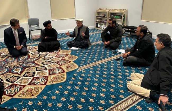 A group of men sitting on a carpet
Description automatically generated