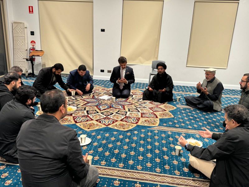 A group of men sitting on a rug
Description automatically generated