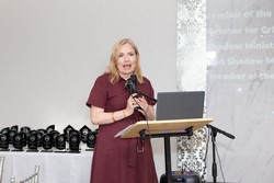 A person standing at a podium

Description automatically generated