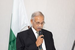 A person in a suit holding a microphone

Description automatically generated
