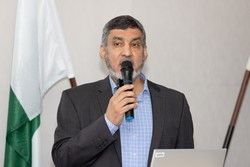 A person speaking into a microphone
Description automatically generated