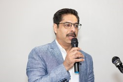 A person holding a microphone

Description automatically generated