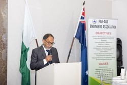 A person standing at a podium with flags behind him
Description automatically generated
