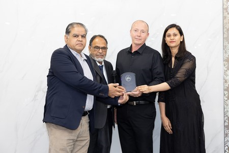 A group of people holding a plaque
Description automatically generated