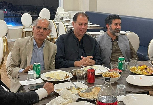 A group of men sitting at a table

Description automatically generated