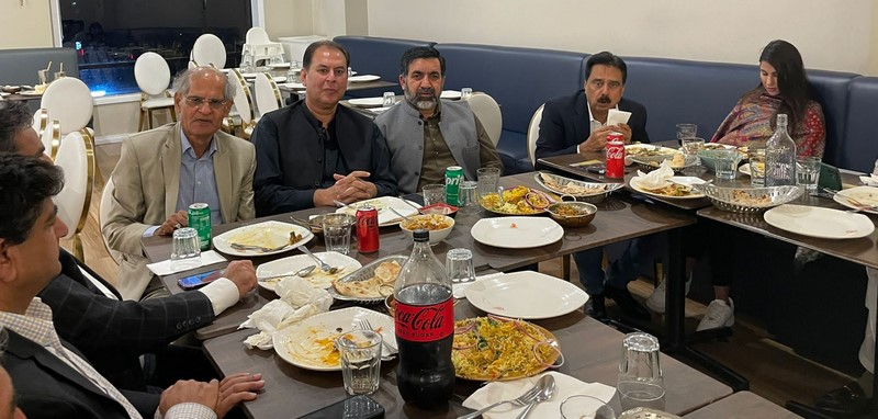 A group of people sitting at a table with food

Description automatically generated