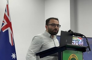 A person standing at a podium
Description automatically generated