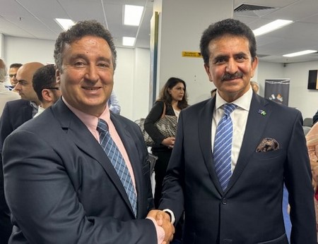 Two men shaking hands in a room
Description automatically generated