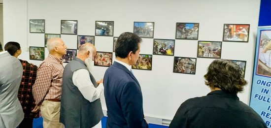 A group of men looking at art on a wall
Description automatically generated