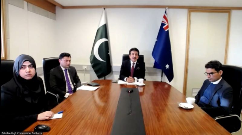 Men sitting at a table with flags
Description automatically generated