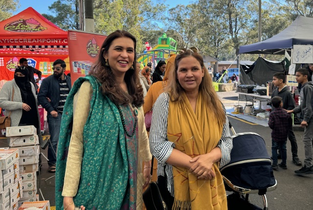 A couple of women standing in a street
Description automatically generated