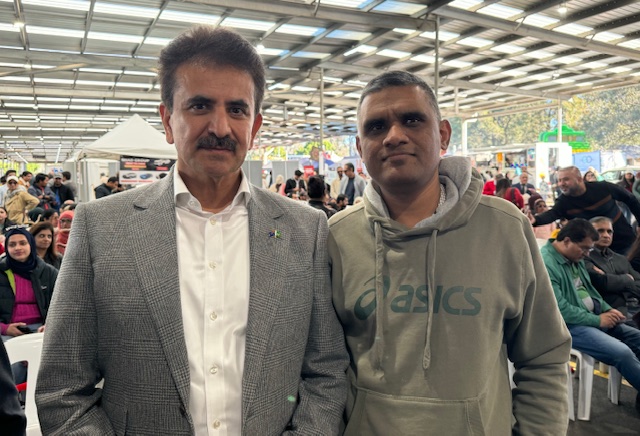 Two men standing together in a tent
Description automatically generated