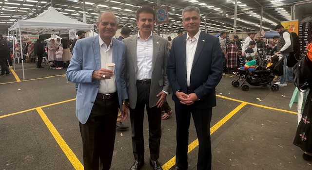 A group of men standing in a parking lot
Description automatically generated
