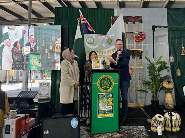 A person and person standing at a podium
Description automatically generated