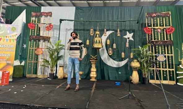 A person standing on a stage
Description automatically generated