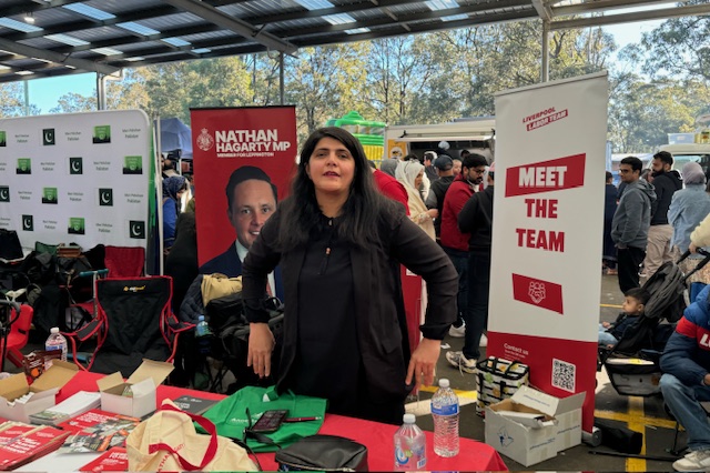 A person standing in front of a booth
Description automatically generated