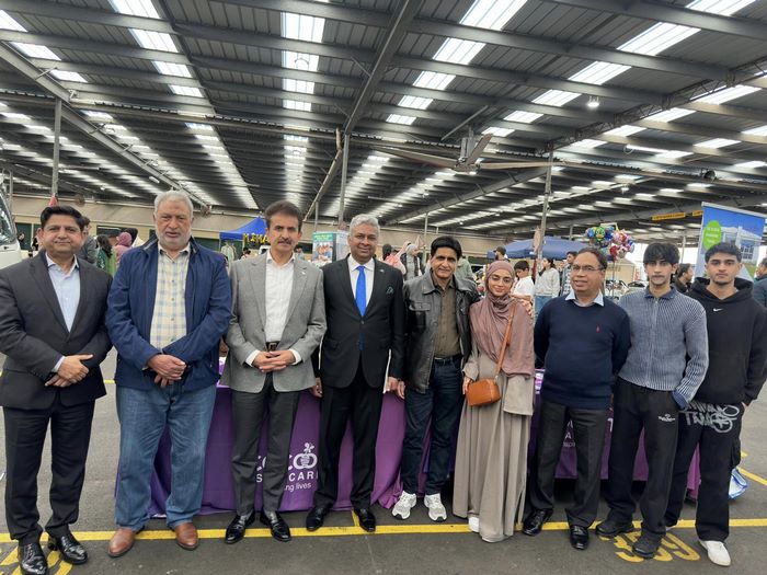 A group of people standing in a large room
Description automatically generated