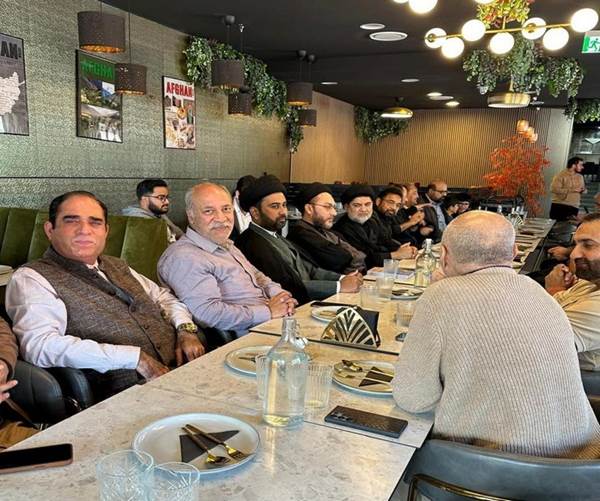 A group of men sitting at a table
Description automatically generated