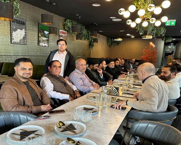 A group of people sitting at a long table
Description automatically generated