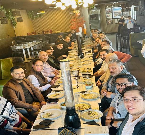 A group of people sitting at a long table
Description automatically generated
