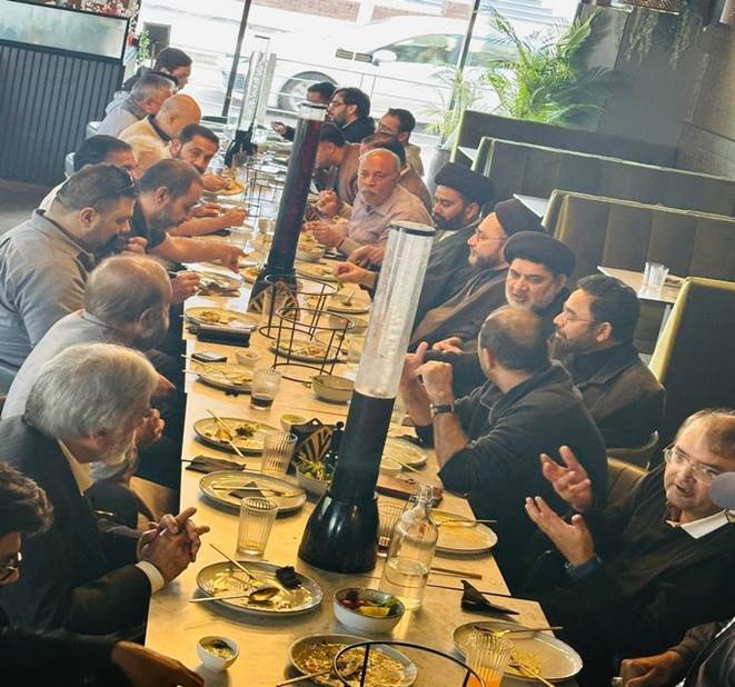 A group of people sitting at a long table
Description automatically generated