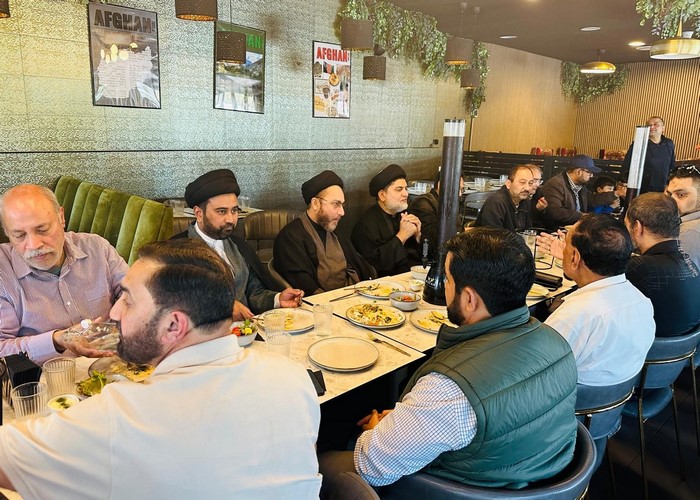 A group of men sitting at a table eating food
Description automatically generated