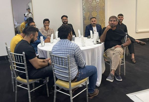 A group of men sitting around a round table

Description automatically generated
