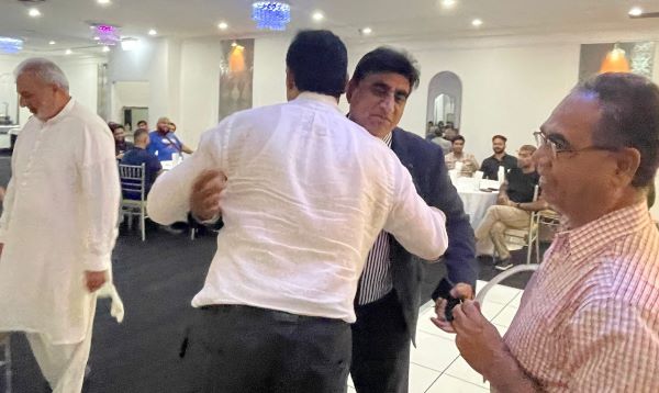 A person in a white shirt holding another person in a white shirt

Description automatically generated