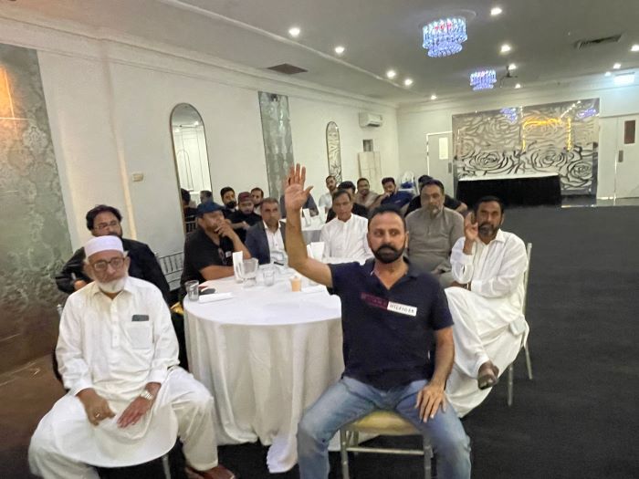 A group of men sitting at a table

Description automatically generated