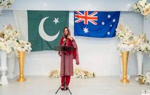 A person standing at a podium with a microphone in front of a flag
Description automatically generated