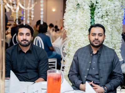 Two men sitting at a table
Description automatically generated