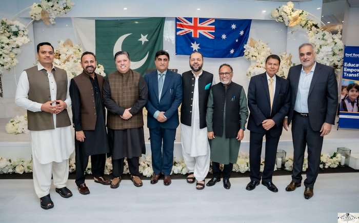 A group of men standing in front of flags
Description automatically generated