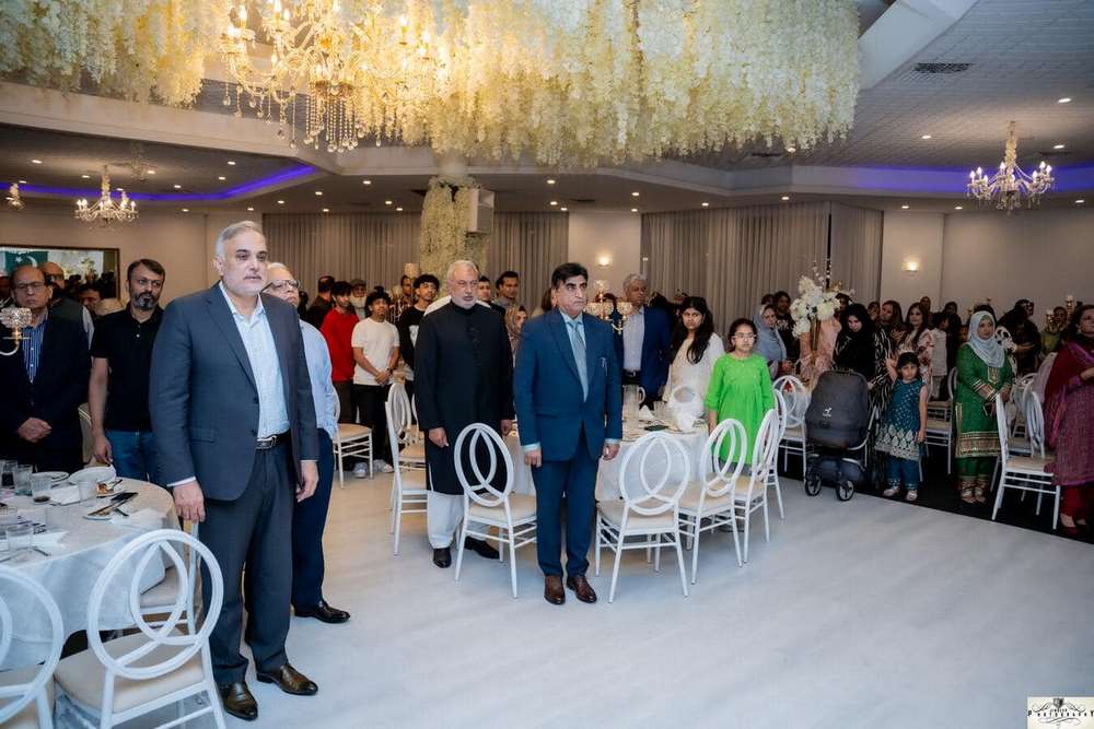A group of people standing in a room
Description automatically generated