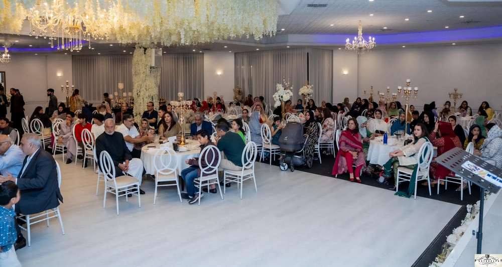 A group of people sitting at tables in a room
Description automatically generated
