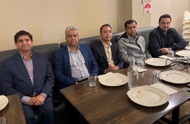 A group of men sitting at a table

Description automatically generated